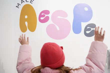 Dziewczynka dotyka napisu Małe AeSPe.