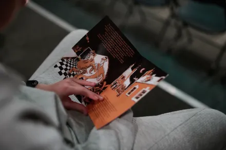 Chłopiec trzyma książeczkę Magicznej Latarni. 