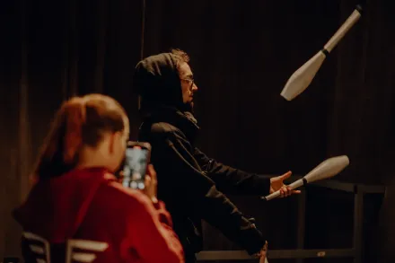 Uczestniczka nagrywa żonglującego kolegę.