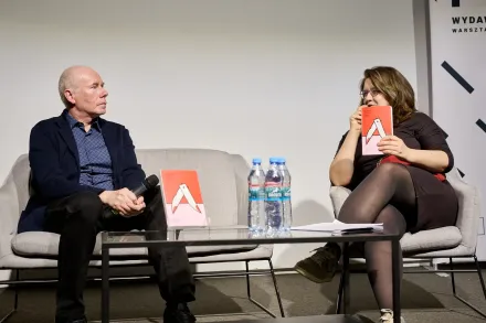 Przy stoliku siedzi kobieta i mężczyzna.  Rozmawiają o książce.