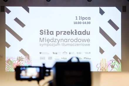 Na ścianie wyświetlona jest z rzutnika grafika z napisem Siła wolnego słowa.