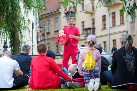 Aktor trzyma w ręce czerwoną lalkę.