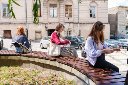 Grupa kobiet wyplata koła z wikliny.