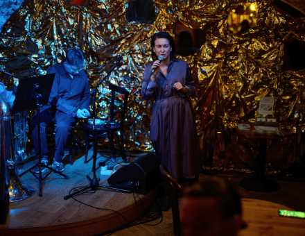 Mężczyzna przygotowuje się do koncertu. Kobieta przemawia do publiczności.