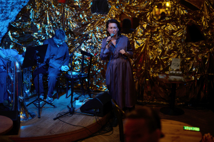 Mężczyzna przygotowuje się do koncertu. Kobieta przemawia do publiczności.