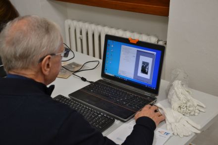 Starszy mężczyzna obsługuje komputer. Wyświetla prezentację.