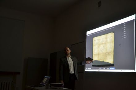 Mężczyzna prezentuje zeskanowane stare zdjęcie. Są na nim zagięcia.