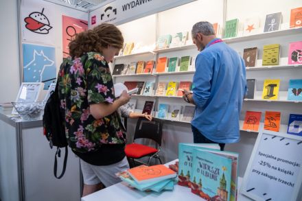 Kobieta i mężczyzna oglądają książki, które wzięli z półek.