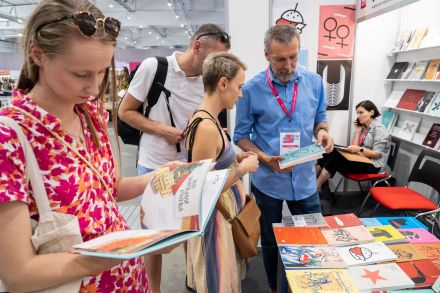 Zdjęcie osób oglądających książki, które wzięli ze stoiska.