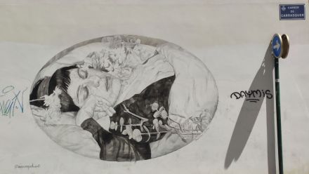 Mural, w kształcie elipsy, przedstawia śpiącą kobietę w pościeli, otoczoną kwiatami. 