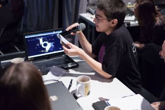 Szkolenie z audiodeskrypcji. Zbliżenie na jednego uczestnika, odczytującego efekt pracy grupowej.