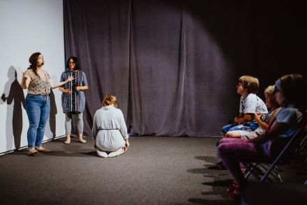 Trzy animatorki odgrywają przed dziećmi scenkę.