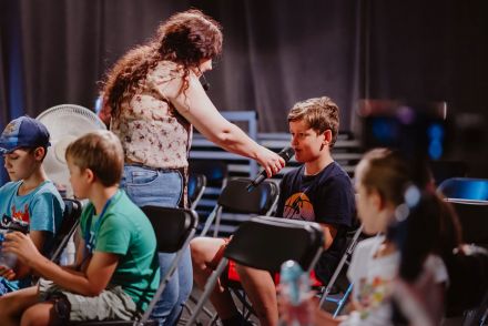 Prowadząca podstawia mikrofon chłopcu.