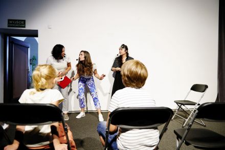 Trzy animatorki odgrywają przed dziećmi scenkę.