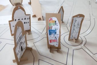 Na zdjęciu widać tekturową makietę  miasta wzbogaconą o umieszczone na niej budynki wykonane przez dzieci.