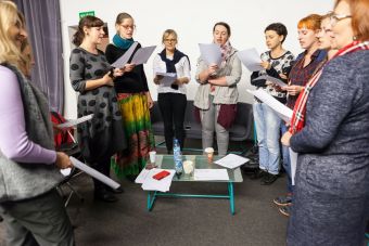 Na zdjęciu wszystkie kobiety stoją, nadal trzymając kartki i śpiewając.