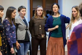 Na zdjęciu widzimy część grupy , która ze skupieniem przygotowuje się wokalnie.