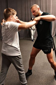 Chłopiec próbuje się bronić przed instruktorem, który udaje napastnika.