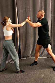 Instruktor pokazuje, jak układać dłoń do ciosu.