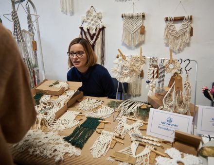 Na zdjęciu widać stoisko z makramami. Wystawca rozmawia z klientami. Na zdjęciu widać stoisko z makramami. Wystawca rozmawia z klientami.