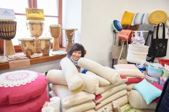 Na zdjęciu widać stoisko z poduszkami, torbami oraz instrumentami (bębny).