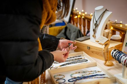 Kobieta ogląda biżuterię na stoisku.