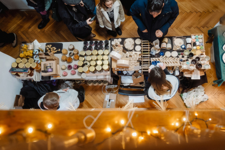 Zdjęcie z góry ze stoiskiem  i ludźmi, którzy coś kupują,