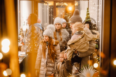 Zdjęcie zrobione przez szybę. Widać ludzi, którzy robią zakupy. 