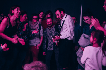 Muzyk grający na  banjo wszedł między rozbawioną publiczność.