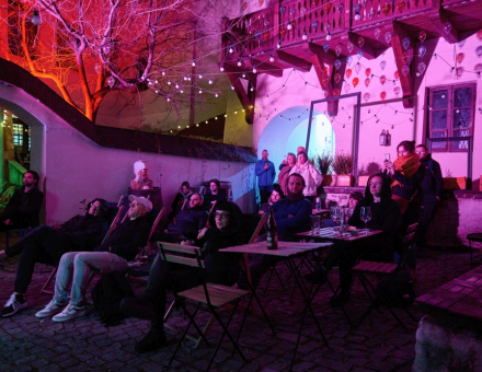 Publiczność zgromadzona w trakcie koncertu siedzi na leżakach na patio Bałaganu.