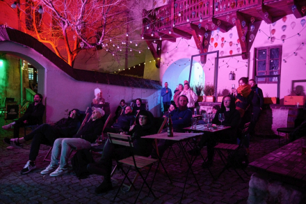 Publiczność zgromadzona w trakcie koncertu siedzi na leżakach na patio Bałaganu.