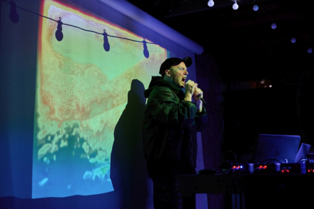 Wokalista śpiewa z mikrofonem w ręku.