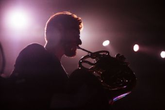 Cień muzyka zespołu Ciśnienie grającego na instrumencie dętym.