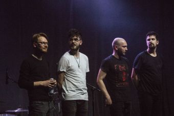 Koncert się skończył. Czterech muzyków zespołu Ciśnienie stoi w rzędzie, bez instrumentów.