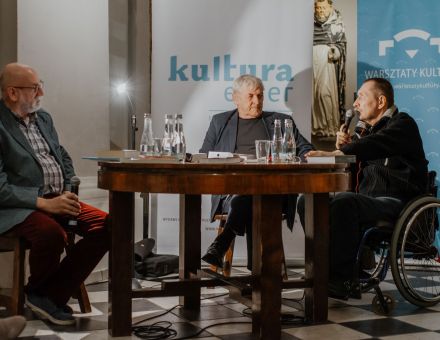 Zbliżenie na autora książki, tłumacza oraz moderatora spotkania. Autor opowiada o książce.