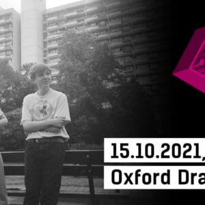 In the photo we see two women at a bench among blocks of flats. On the left, the logotype of Different Sounds Zone and the inscription 15.10.2021 Oxford Drama