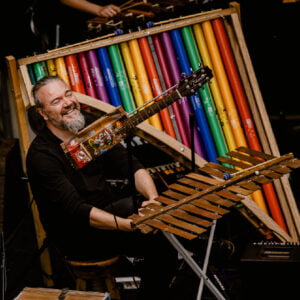 Zdjęcie przedstawia mężczyznę grającego na instrumentach