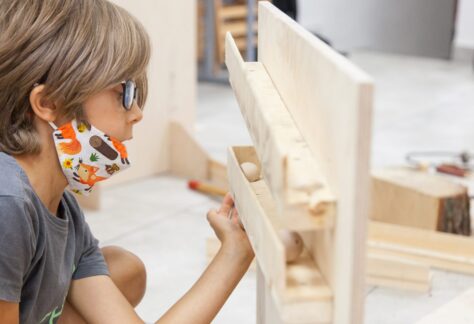 Chłopiec bawi się drewnianą kulką.