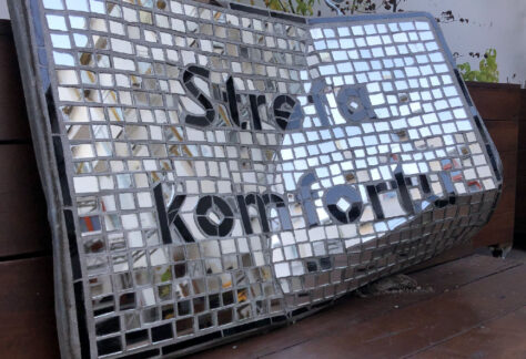 Zdjęcie przedstawia dzieło sztuki - znak drogowy z lustrzanej mozaiki