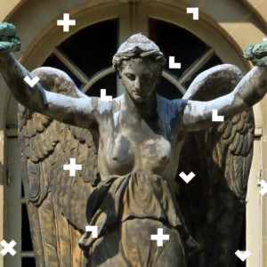 Zdjęcie ponika kobiety-anioła. Ma nagie piersi, od których zaczyna się jej suknia. Znajduje się na tle okna i ściany budynku. Na całym zdjęciu są elementy logotypu Warsztatów Kultury.