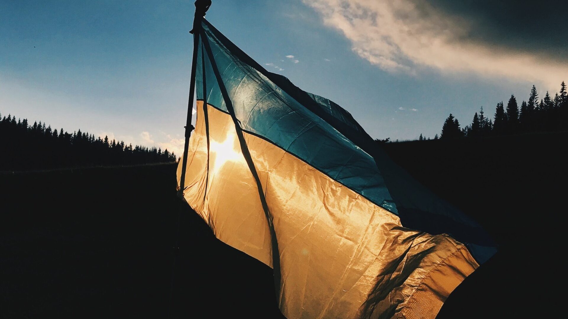 Flaga Ukrainy na tle zachodzącego słońca.
