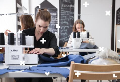 Na zdjęciu widać trzy kobiety przy maszynach do szycia. Drobne elementy graficzne przypominające bloki z gry tetris porozrzucane są na całym obrazku.