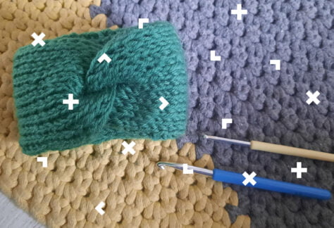 Opaski wełniane na rękę oraz dwa szydełka.