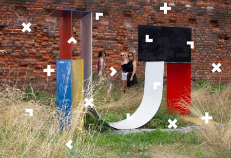 Trzy dziewczyny przyglądające się współczesnej instalacji artystycznej.