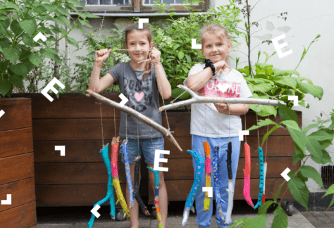 Dwie dziewczynki prezentują zrobione przez siebie dzwonki wietrzne