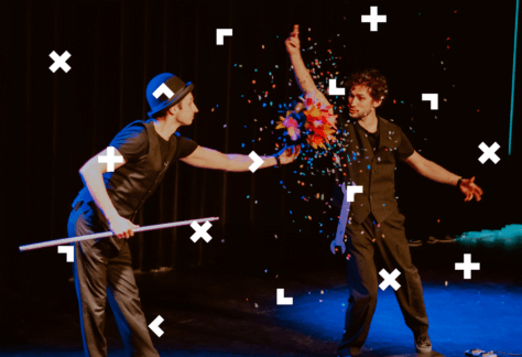 Dwaj mężczyźni na scenie. Jeden z nich trzyma kolorową kolę, z której wysypuje się confetti.