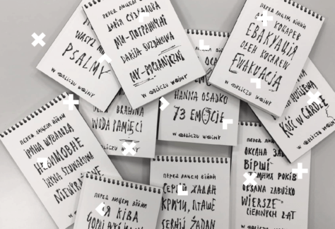 Na białym tle leży sterta notatników z