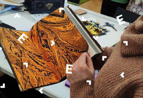 Zbliżenie na dłonie kobiety, która przekłada strony w książce.