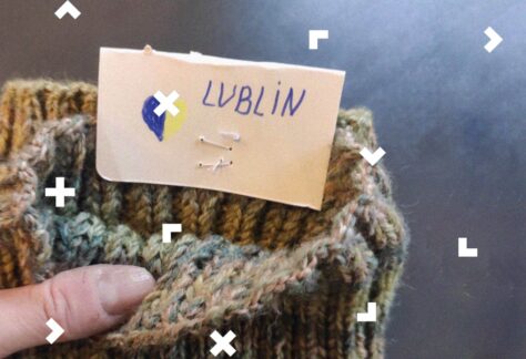 Kobieca dłoń trzyma skarpetę z metką, na której jest niebiesko-żółte serduszko i napis "Lublin".