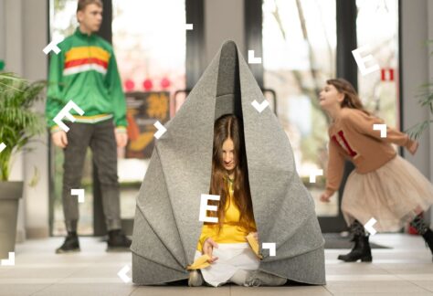 Dziewczynka zamyka się w kokonie - mobilnej strefie ciszy. Za nią po pomieszczeniu biega dwoje dzieci.